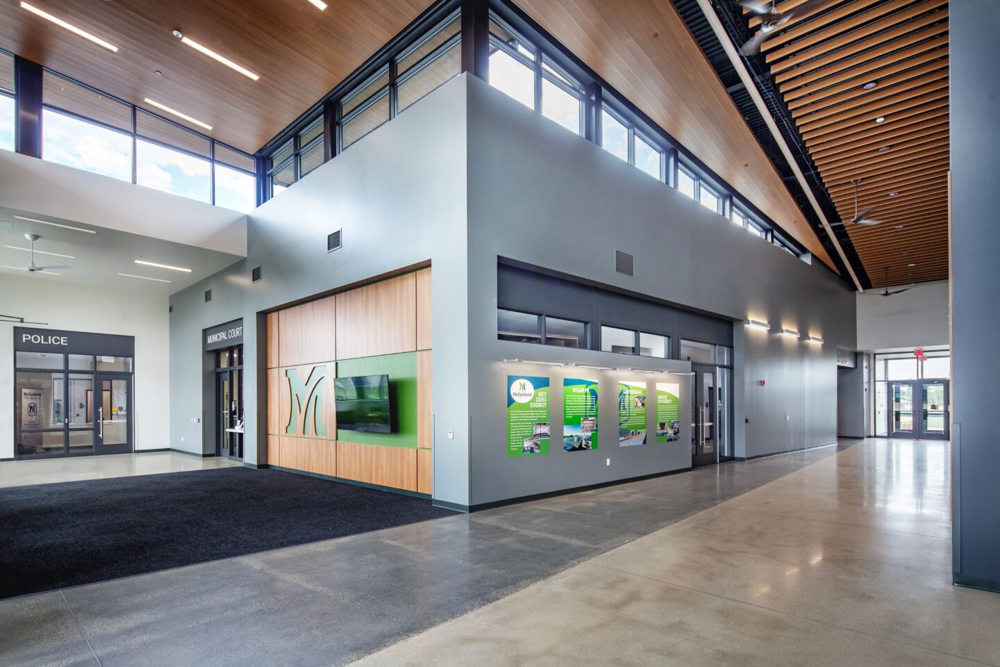 Lobby area featuring clerestory windows, police and municipal court entrances and branding graphics on the wall
