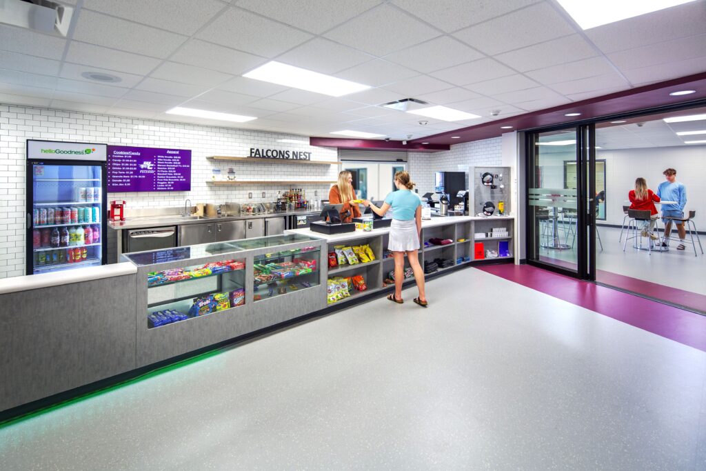 School store with a students purchasing a snack and the sliding doors open to the corridor/collaboration area