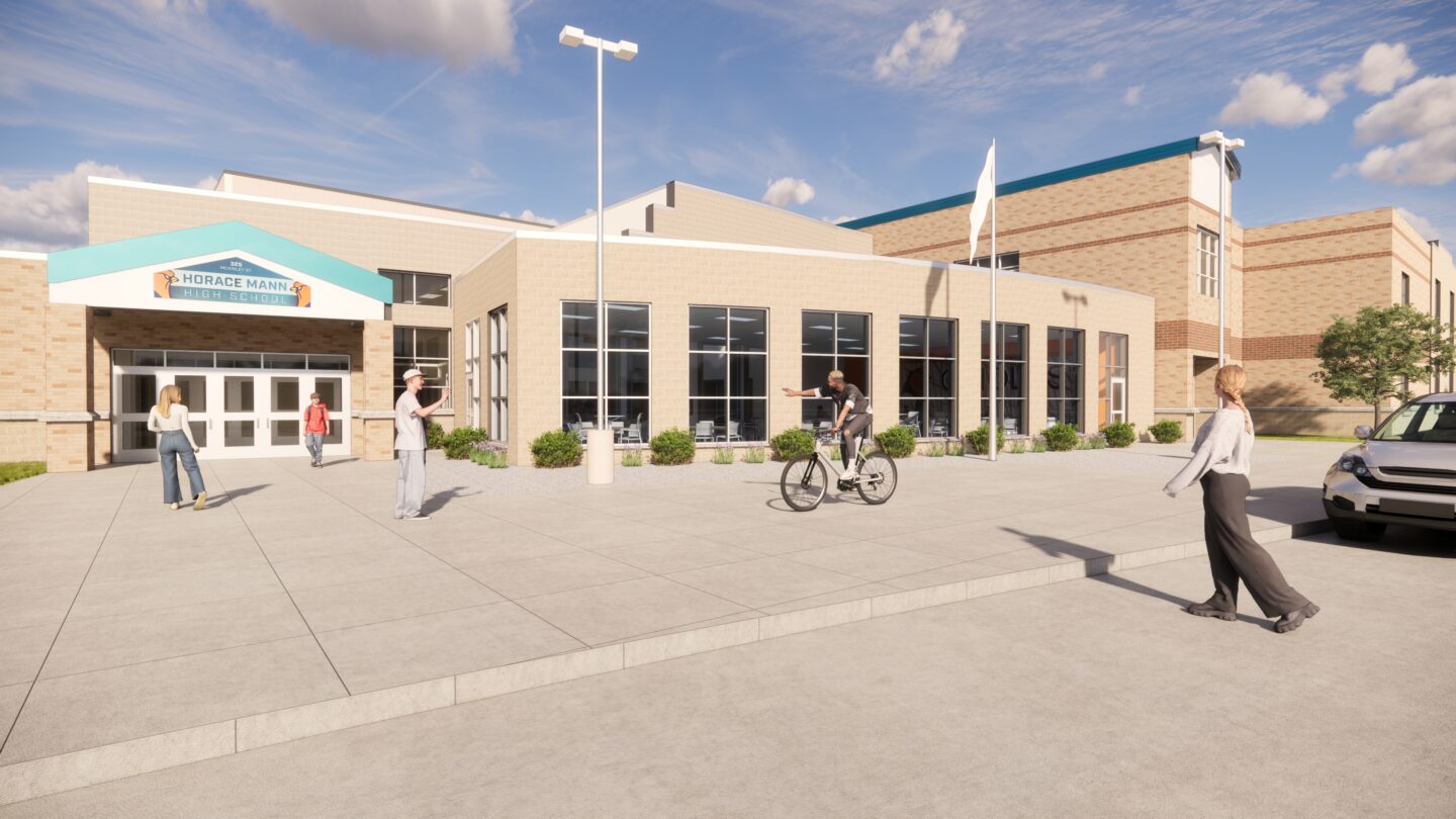 Exterior of the commons area with large windows and students walking on the sidewalk