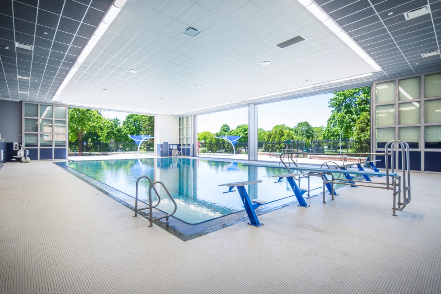 Indoor pool looking at outdoor pool with doors open